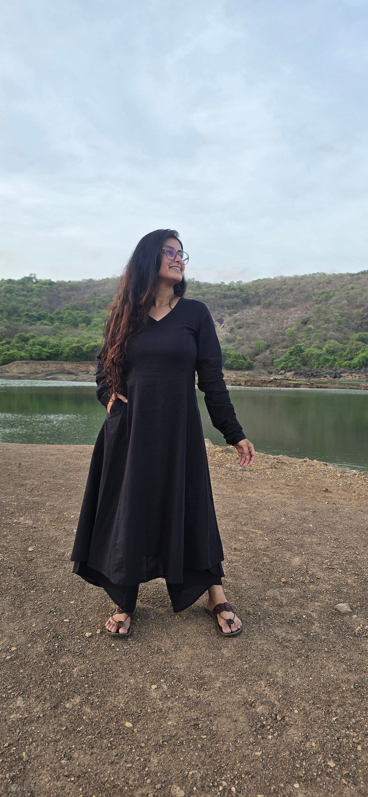 Woman wearing a black kurta outdoors beside a lake